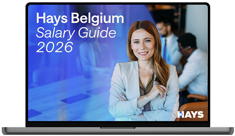 Laptop screen displaying the Hays Belgium Salary Guide 2026 cover, featuring text on a blue background with a person in business attire in the foreground and others in the background.
